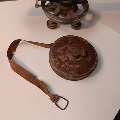 VINTAGE SURVEYORS TRANSIT LEVEL AND AN ANTIQUE TAPE MEASURE