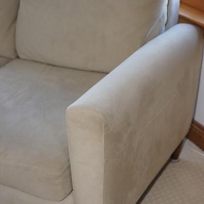 Contemporary style quality three cushion ultra suede style fabric sofa of a light olive-green color.