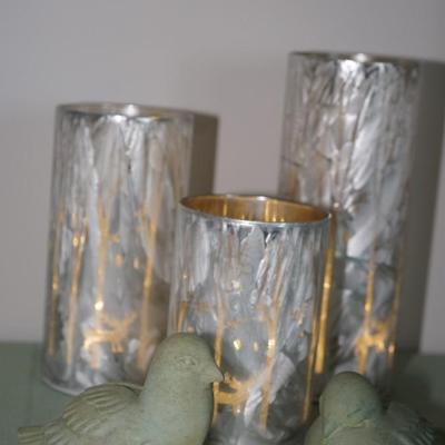 Grouping of three graduated height lanterns, forest trees and antlered deer and birds
