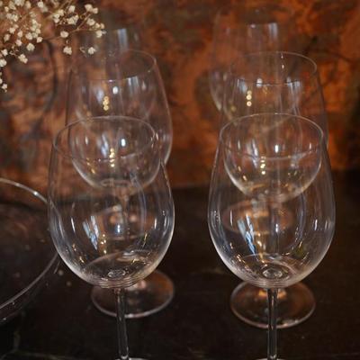 Sale Photo Thumbnail #132: A table grouping for the celebration. 
set of six Nachtmann signed 20 oz wine glasses
set of four 16 oz Louis Bergolli  wine glasses
8" glass centerpiece candleholder with platform base
glass tazza to service cheese or other. ( slight fog to an area on th