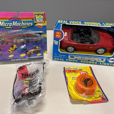 Micro machines a Camaro that makes sounds a Duncan yo-yo and a Shrek McDonald’s happy meal toy