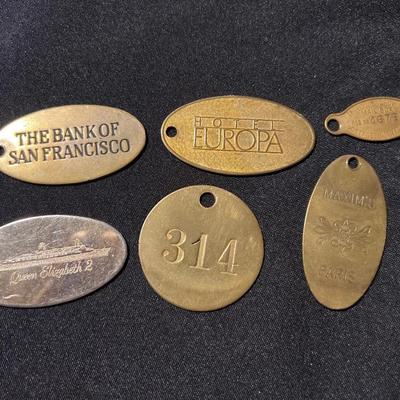Six brass luggage tags