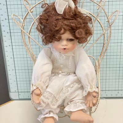 Small porcelain doll with chair and clothes
