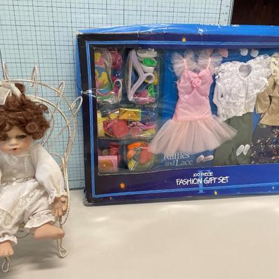 Small porcelain doll with chair and clothes