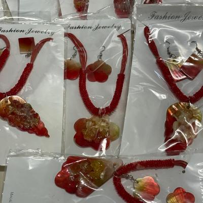 Multiple sets of red fashion jewelry in a small storage container