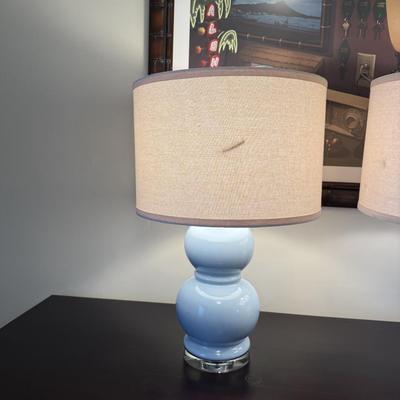 Sale Photo Thumbnail #74: The Robert Abbey Table Lamp is a modern lighting solution designed for the living room. It features a blue ceramic base with a glazed finish and a fabric gourd-shaped shade. The lamp uses LED lighting technology and is powered by a wall plug-in. It includ