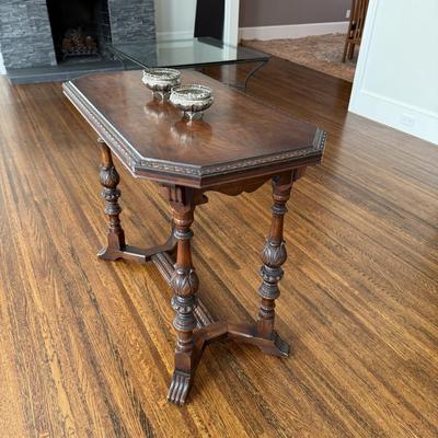 Sale Photo Thumbnail #89: This antique center table is crafted from walnut wood and features a sturdy construction with decorative carved elements. It has an octagonal shape and comes in a brown color, fitting well in vintage, neoclassical, or traditional styled rooms such as the 