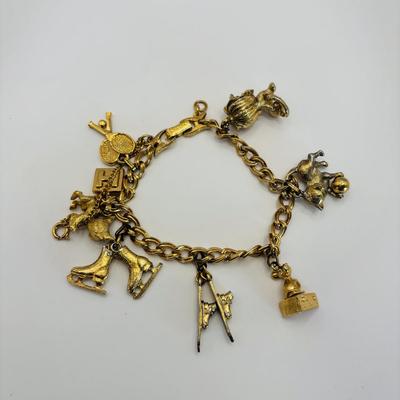 LOT 313: Monet Charm Bracelet with 8 Charms. Chain is 7.5" and has Safety Chain & More