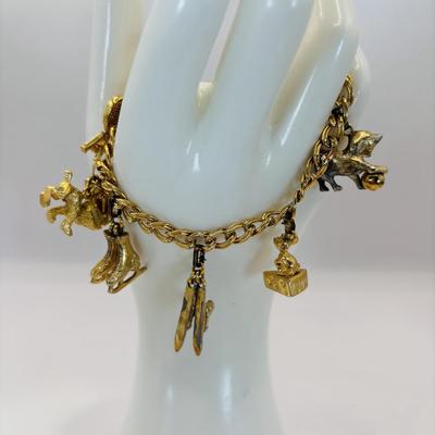 LOT 313: Monet Charm Bracelet with 8 Charms. Chain is 7.5" and has Safety Chain & More