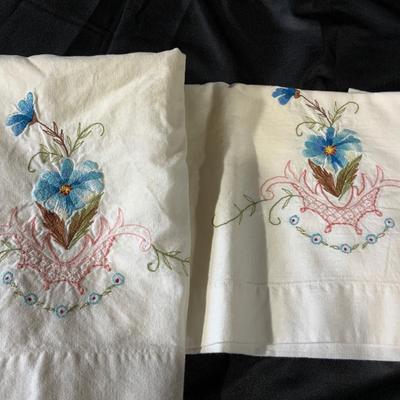 Lot of embroidered pillowcases, including one with floral appliqué