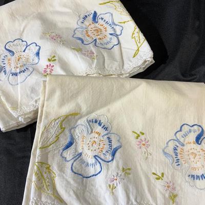 Lot of embroidered pillowcases, including one with floral appliqué