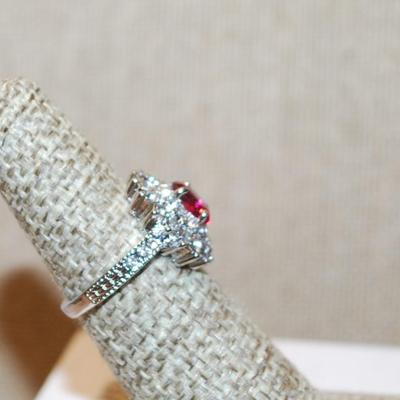 Size 5½ Oval Red Stone Ring in a Glitter Starburst Setting with a Silver Tone Band (4.7g)