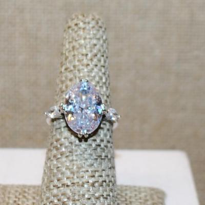 Size 6 Large Oval Clear Stone Ring with Horizontal Side Accents on a Silver Tone Band (4.4g)