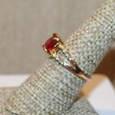 Size 8 Single Clear Red Round Stone Ring with 2 Rows Side Accent Stones on a Gold Tone Band (2.7g)