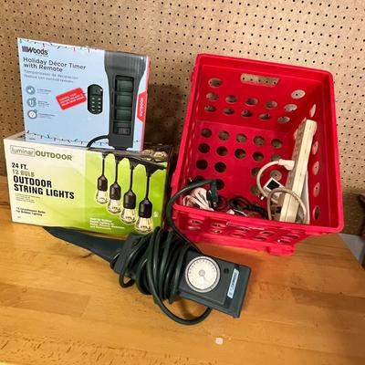 Lot 280 Plastic crate of outdoor string lights, outdoor lighting timer and power strips