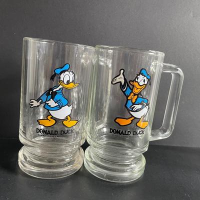 LOT 24: Winnie the Pooh & Piglet Souvenir Mugs (4.5”H), and Five (5) Vintage Glass Mugs of Assorted Disney Characters by Walt Disney...