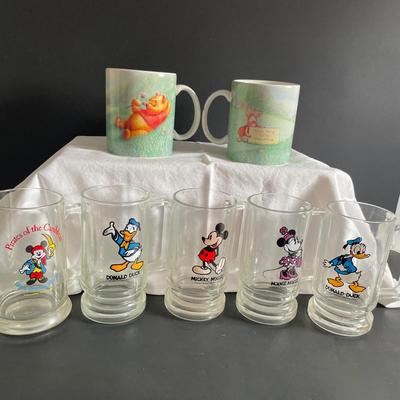 LOT 24: Winnie the Pooh & Piglet Souvenir Mugs (4.5”H), and Five (5) Vintage Glass Mugs of Assorted Disney Characters by Walt Disney...