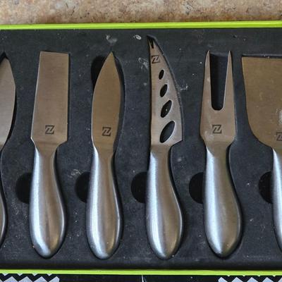 LOT 30K: Nambre Cheese Cutting Board With Knife, Zazza Knife and Serving Set, and Zazza 5 Piece Slate Cheese Marker Set