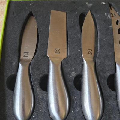 LOT 30K: Nambre Cheese Cutting Board With Knife, Zazza Knife and Serving Set, and Zazza 5 Piece Slate Cheese Marker Set