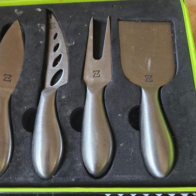 LOT 30K: Nambre Cheese Cutting Board With Knife, Zazza Knife and Serving Set, and Zazza 5 Piece Slate Cheese Marker Set