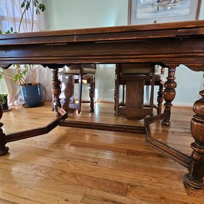 Antique English Jacobean Revival Oak table with pull out end leaves and six chairs