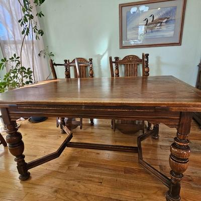 Antique English Jacobean Revival Oak table with pull out end leaves and six chairs