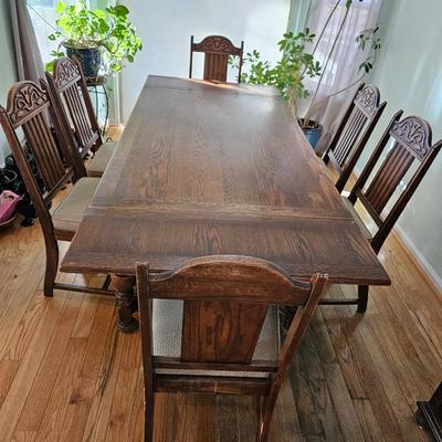 Antique English Jacobean Revival Oak table with pull out end leaves and six chairs