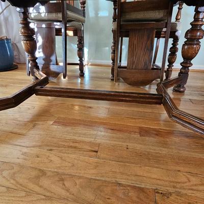 Antique English Jacobean Revival Oak table with pull out end leaves and six chairs