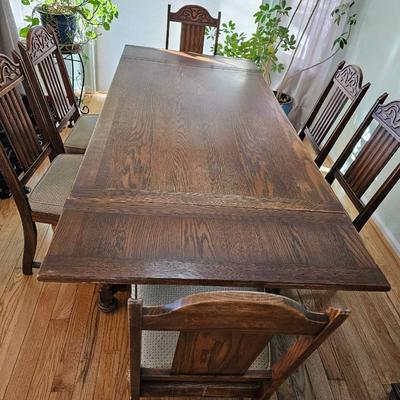 Antique English Jacobean Revival Oak table with pull out end leaves and six chairs