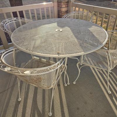 Heavy wrought iron patio table with Four nice chairs with cushions