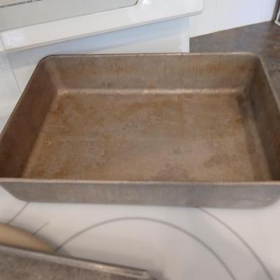 Pampered Chef 15 inch handled pizza stone with glass cutting board and a lidded metal cake pan