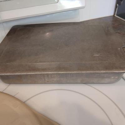 Pampered Chef 15 inch handled pizza stone with glass cutting board and a lidded metal cake pan