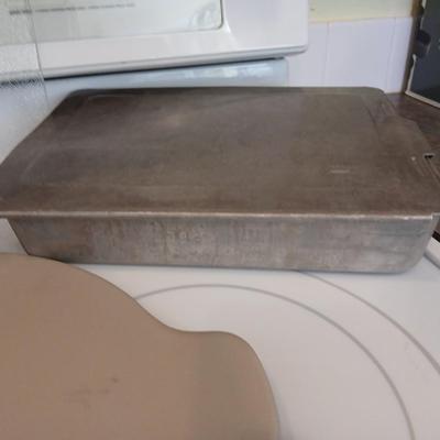 Pampered Chef 15 inch handled pizza stone with glass cutting board and a lidded metal cake pan