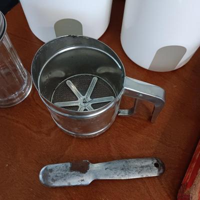 WOODEN SLAT SERVING BLOCK, HAND MIXER, FLOUR SIFTER, SUGAR POURER AND PLASTIC CANISTERS