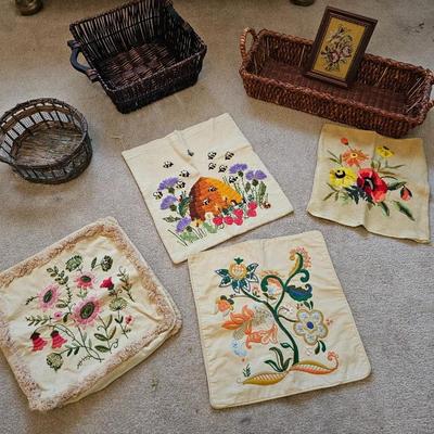 Four Vintage Crewel Embroidery Pillowcases with a variety of wicker baskets and a framed floral embroidered wall art