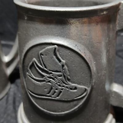 Four Pewter Collectible Beer Steins - One with a bell in the bottom.