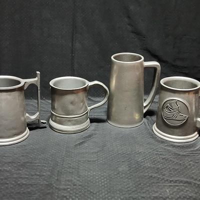 Four Pewter Collectible Beer Steins - One with a bell in the bottom.