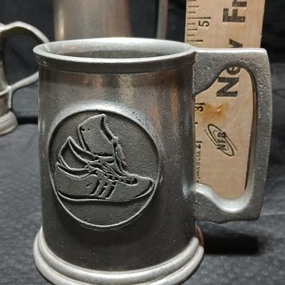 Four Pewter Collectible Beer Steins - One with a bell in the bottom.