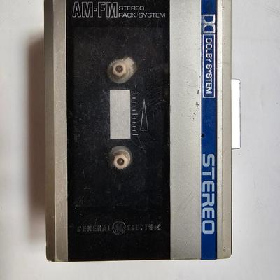 Cassette tapes rock and roll and others in an organizer bag with a vintage GE AM-FM sportsman radio cassette player