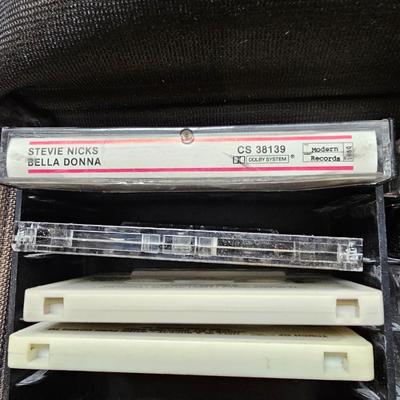 Cassette tapes rock and roll and others in an organizer bag with a vintage GE AM-FM sportsman radio cassette player
