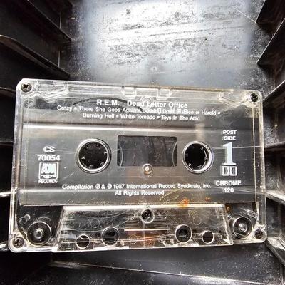 Cassette tapes rock and roll and others in an organizer bag with a vintage GE AM-FM sportsman radio cassette player