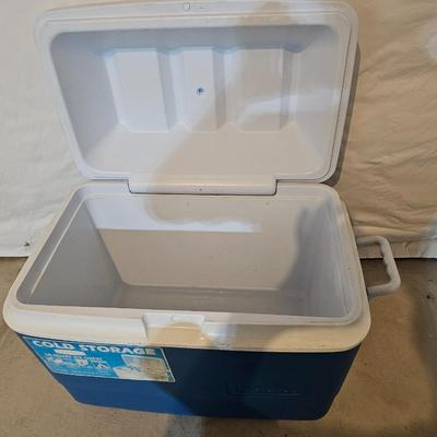 Rubbermaid 50 Quart cooler with two fishpoles, tackle box, and a water bottle