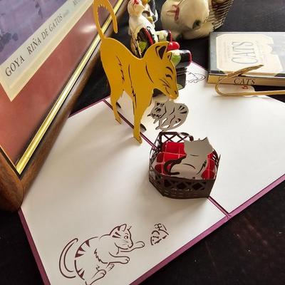 Everything cat! Cat figures, book with bookmarker, glass cat, and framed Goya Rina De Gatos detalle