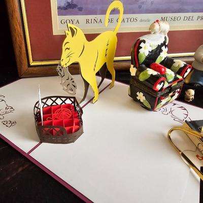 Everything cat! Cat figures, book with bookmarker, glass cat, and framed Goya Rina De Gatos detalle