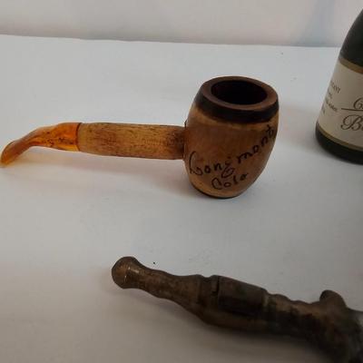 Two small tobacco pipes, champagne bubbles and a miniature metal dagger