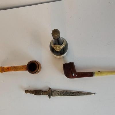 Two small tobacco pipes, champagne bubbles and a miniature metal dagger