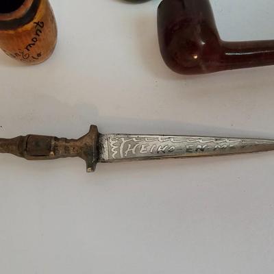 Two small tobacco pipes, champagne bubbles and a miniature metal dagger