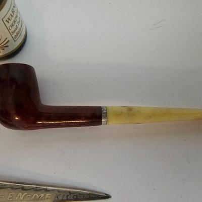 Two small tobacco pipes, champagne bubbles and a miniature metal dagger