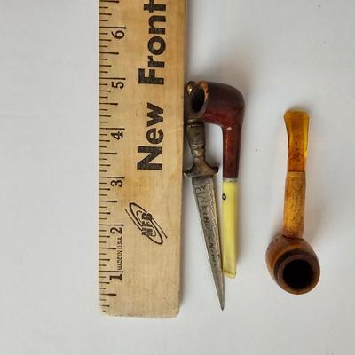 Two small tobacco pipes, champagne bubbles and a miniature metal dagger