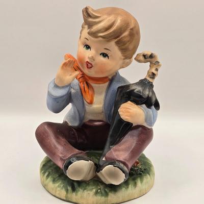 LOT 272: Enesco Boy Figure with Umbrella & Vintage Goebel HUMMEL Figure of Boy on Fence